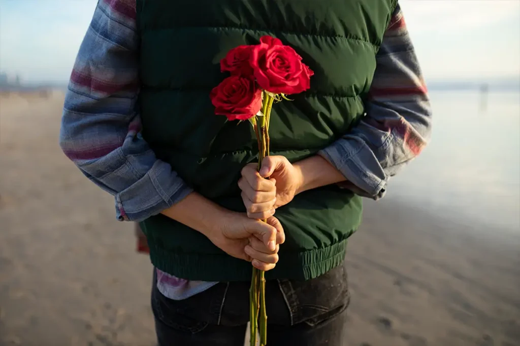 Relationship distress is illustrated with a photo of a person on a beach holding red roses behind their back, symbolizing an effort that may not be enough.