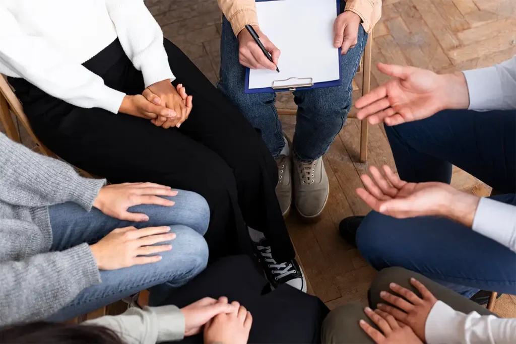 An overhead view of a support group sitting in a circle, illustrating readers to decide if group therapy is a good fit for them.