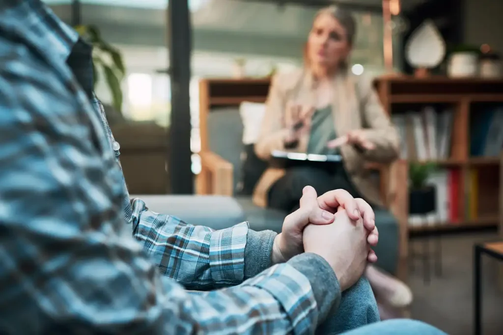 When To Get Help For Anxiety' is illustrated by a photo of a person talking with a therapist in an office setting at Ignite Counseling Colorado.