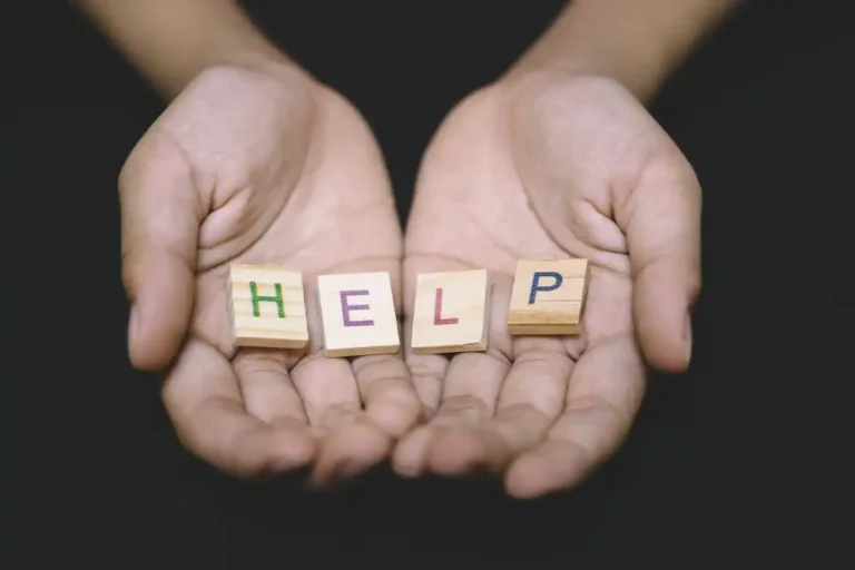 Hands holding letter tiles that spell 'HELP' depicting why it's important to get help for EMDR.