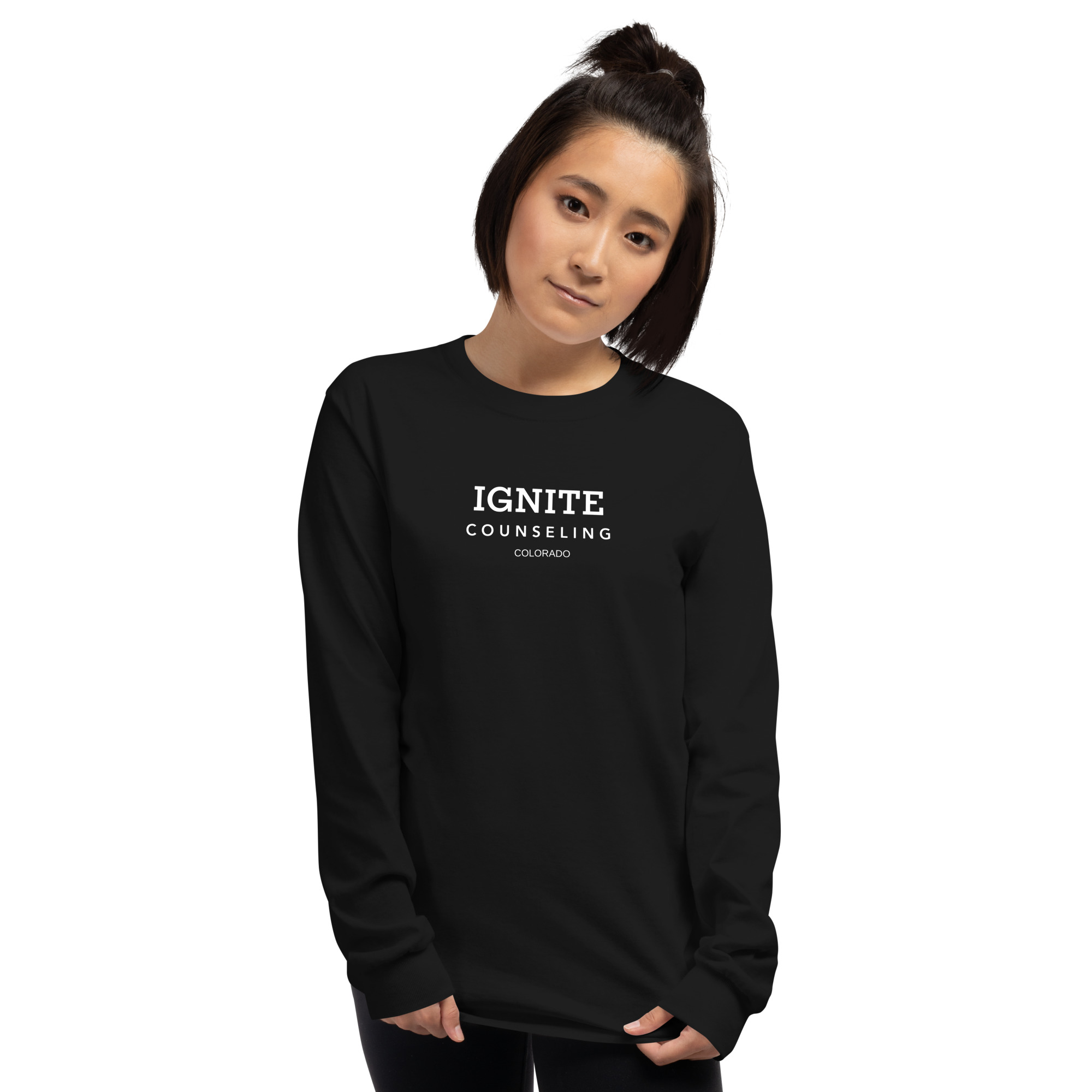 Woman modeling a black long-sleeve t-shirt featuring the Ignite Counseling Colorado logo.