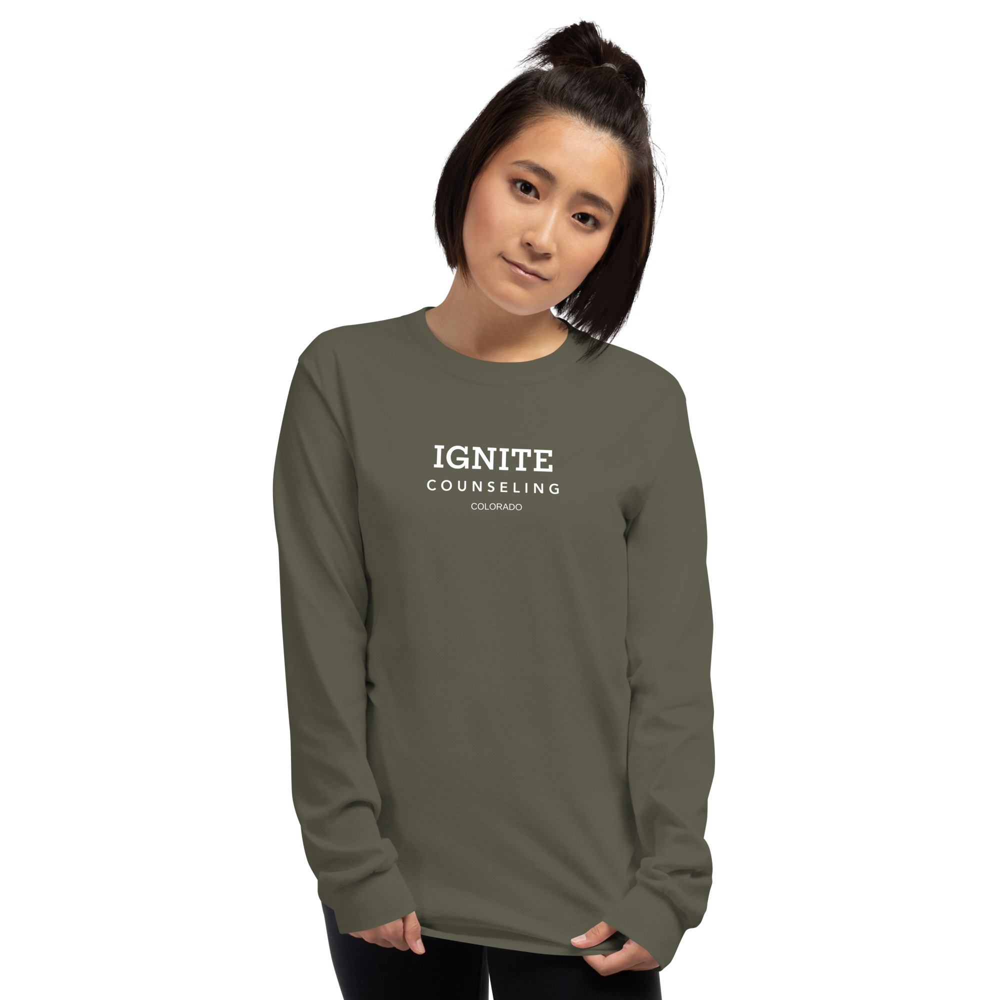 Woman modeling a military green long-sleeve t-shirt featuring the Ignite Counseling Colorado logo.