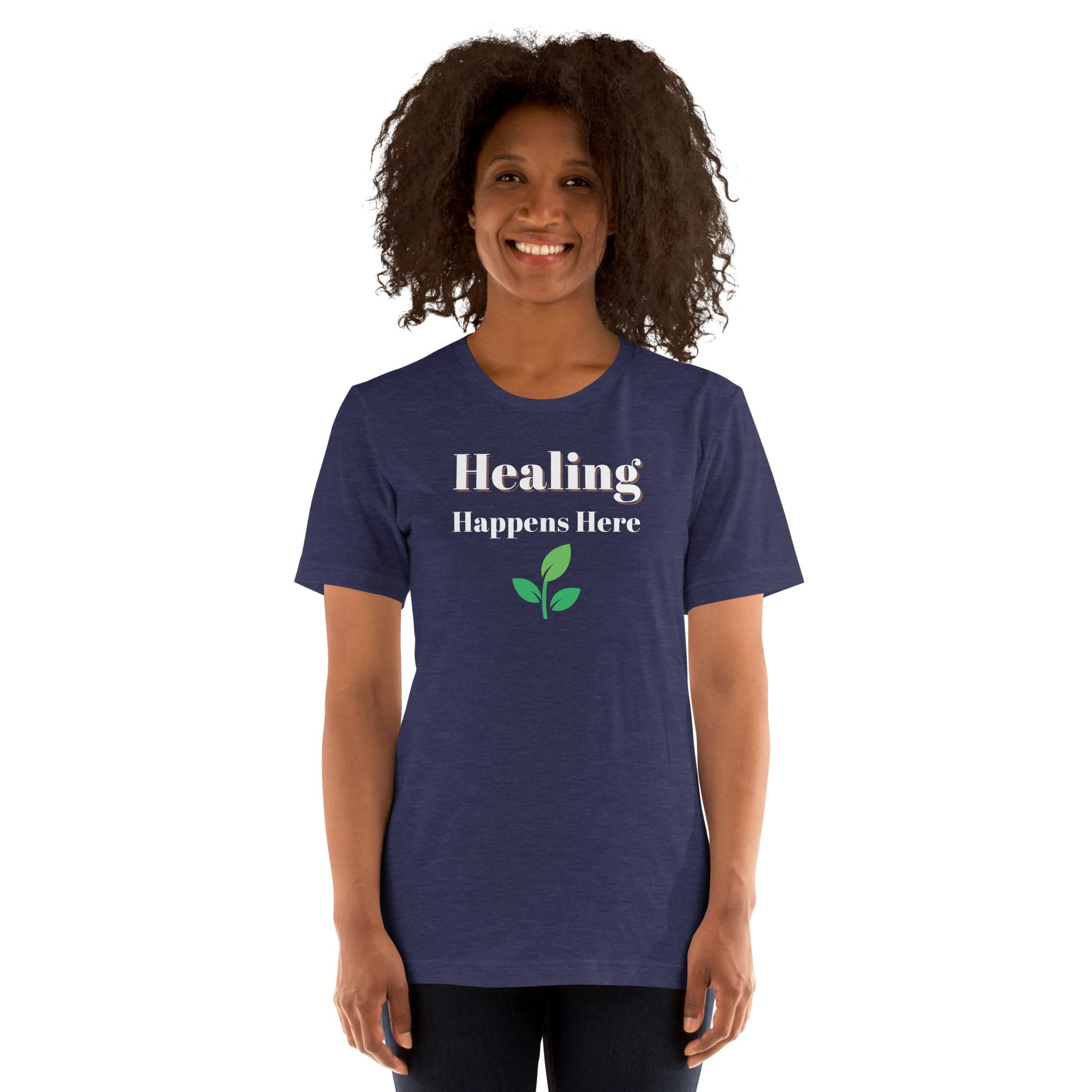 Smiling woman modeling a heather navy t-shirt featuring the text 'Healing Happens Here' and a green leaf graphic.