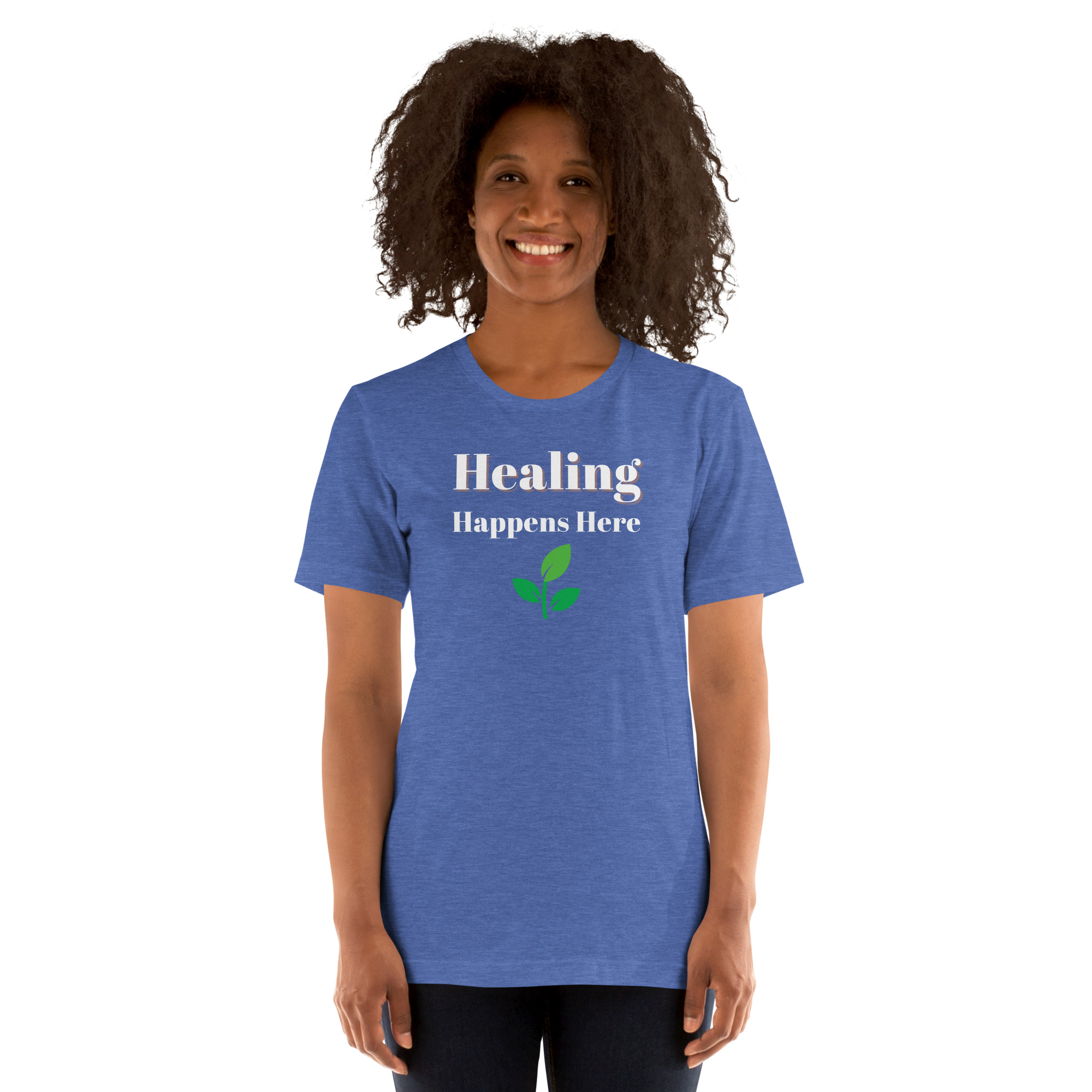 Smiling woman modeling a heather royal blue t-shirt featuring the text 'Healing Happens Here' and a green leaf graphic.