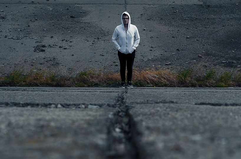 An image conveying the feeling of being stuck in anxiety. A person stands alone on a cracked road, representing a crossroads of fear, symbolizing ERP as the path forward.