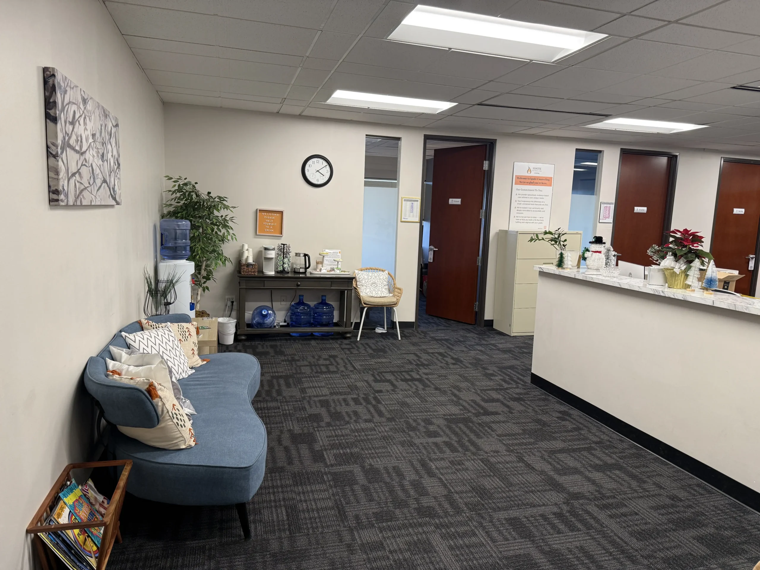 Ignite Counseling Colorado reception area featuring a front desk, refreshment station, and comfortable seating.