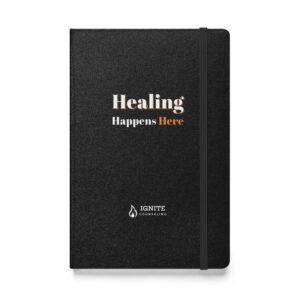 Black hardcover journal featuring the Ignite Counseling logo and the phrase 'Healing Happens Here'.