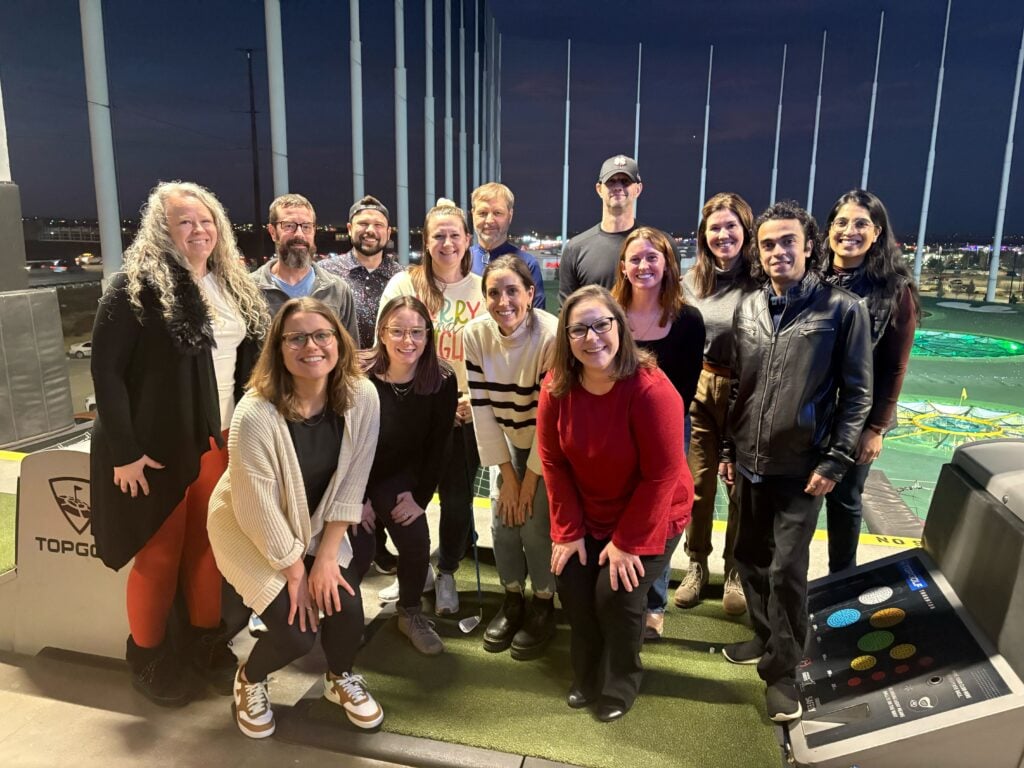 Therapy Austin team members smiling together during a staff outing at Topgolf.